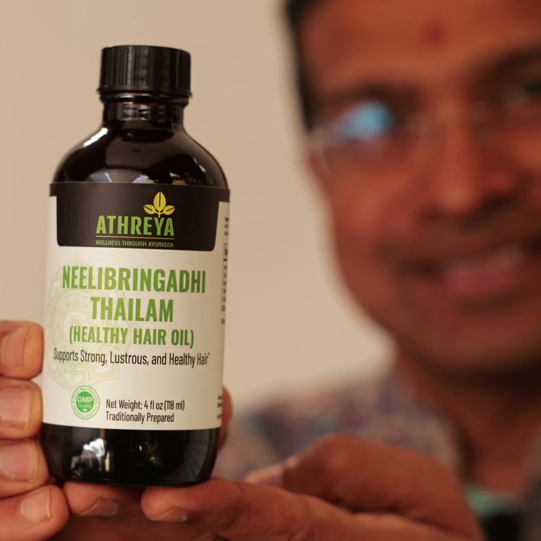 Vaidya Jay holding a bottle of Athreya Neelibringadhi Thailam, Healthy Hair Oil